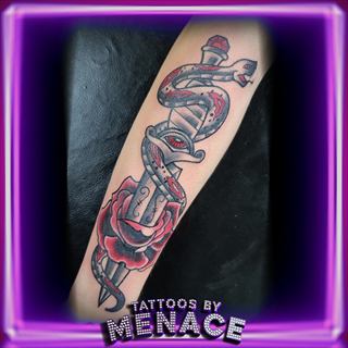 Traditional snake and dagger tattoo on the forearm