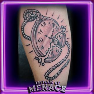 Black and grey pocket watch tattoo on the arm